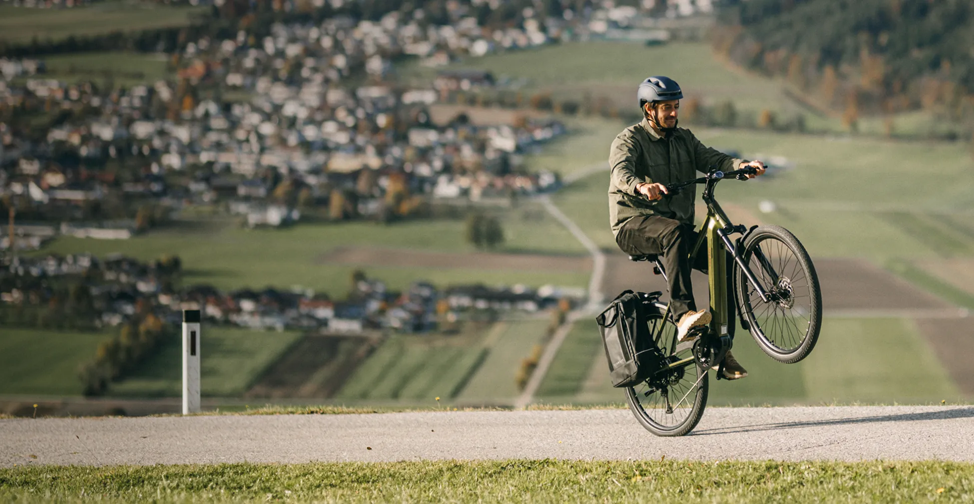 Tenways AGO electric bike being ridden on a hill with countryside in the background