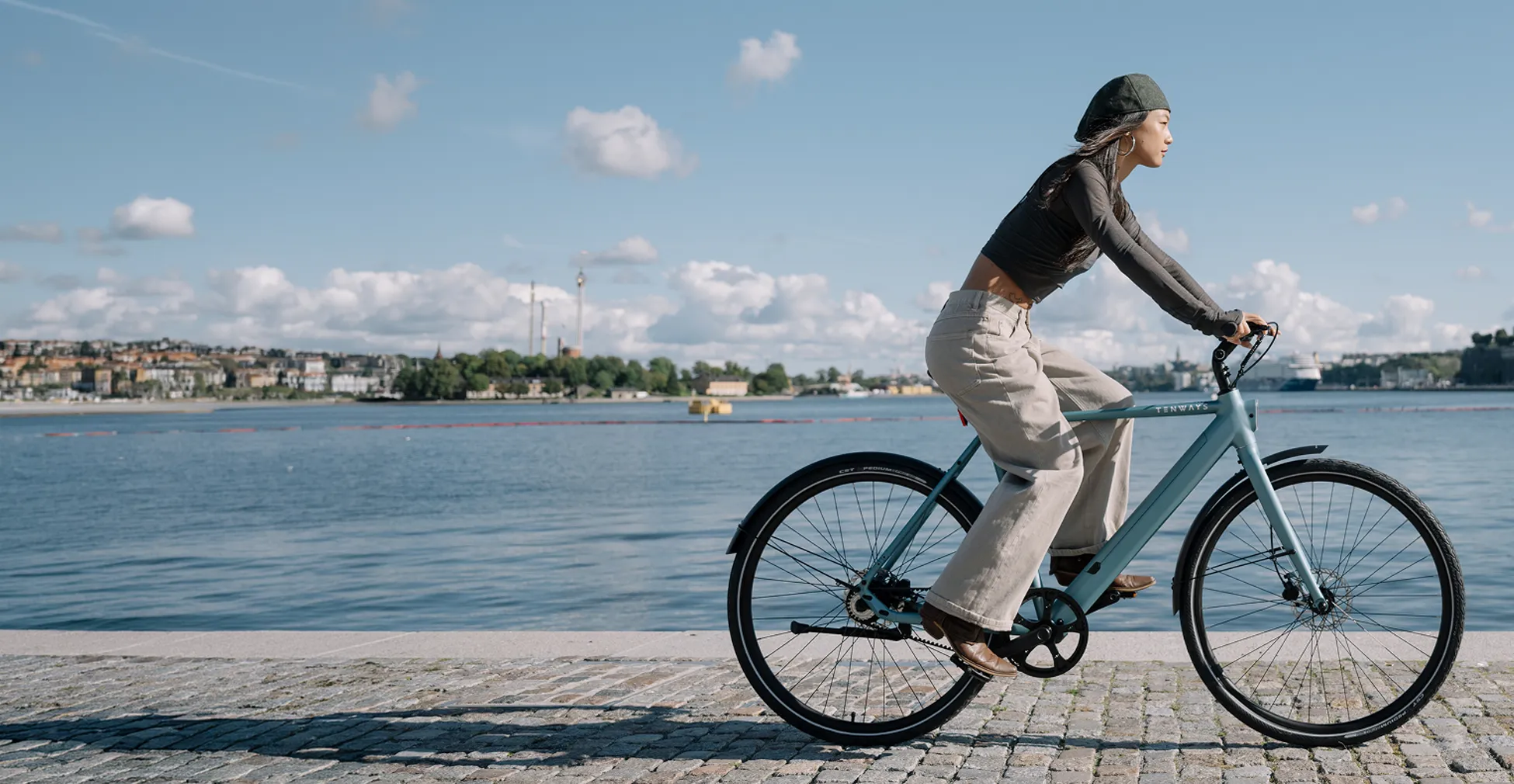 Tenways CGO electric bike being ridden beside the water in an urban setting